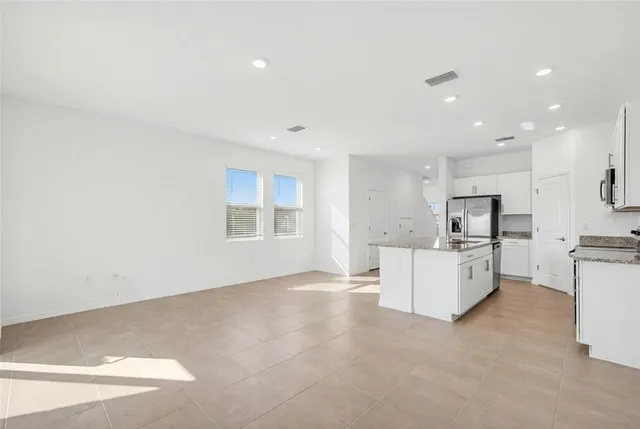a view of kitchen with furniture and refrigerator