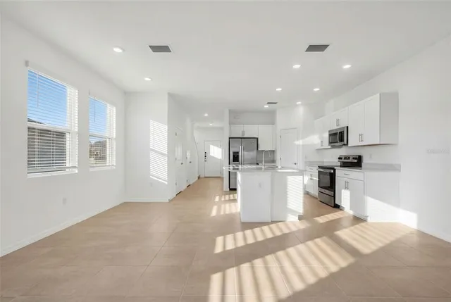 a kitchen with white cabinets and counter space