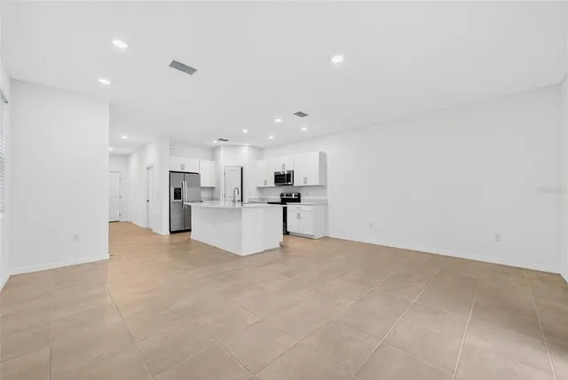 a view of a kitchen with refrigerator and a microwave