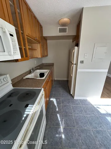 a kitchen with a sink a refrigerator and washer