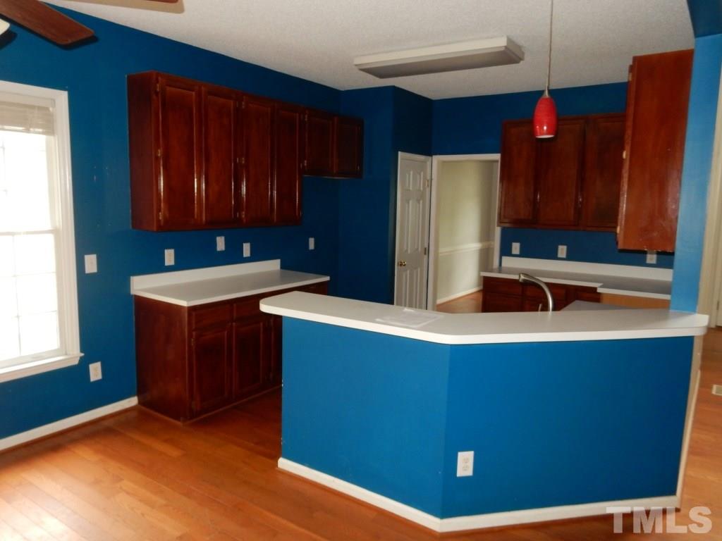 5313 Denmead Way Raleigh, NC 27613 - Photo 5 of 18 a kitchen with stainless steel appliances a refrigerator and wooden cabinets