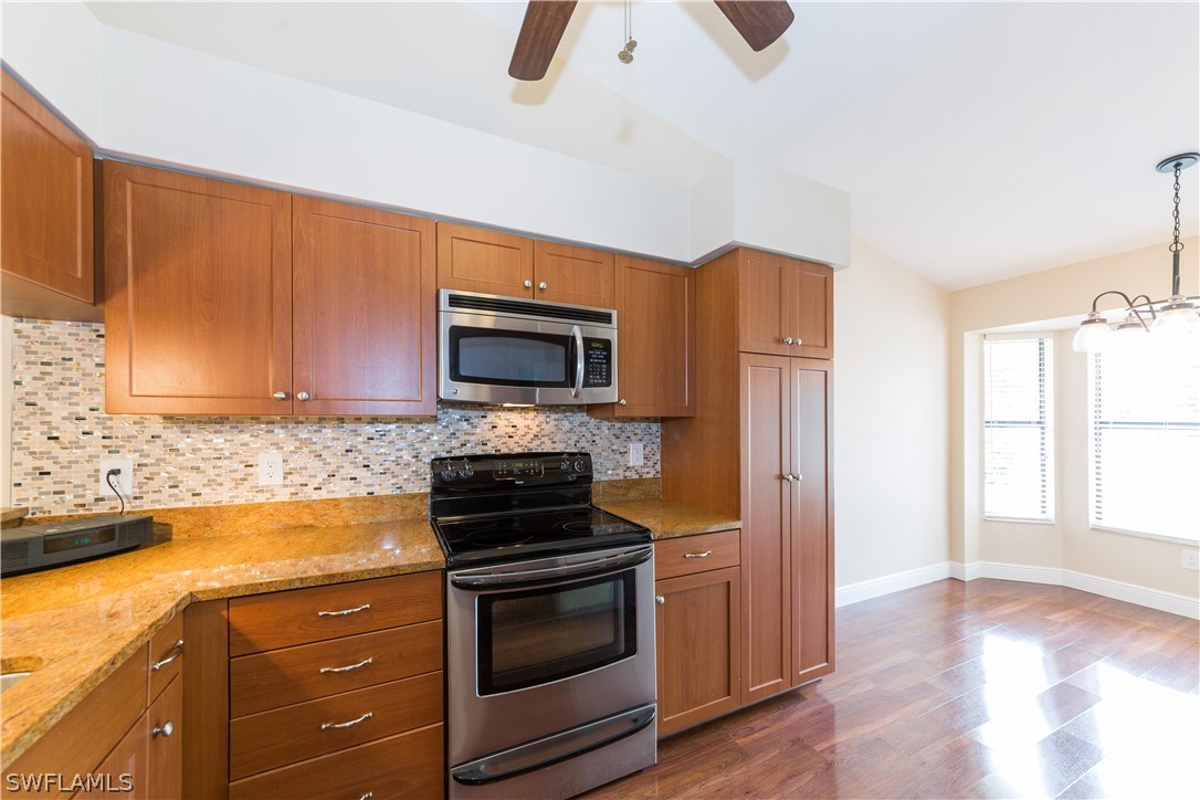 13258 Heather Ridge Loop Fort Myers, FL 33966 - Photo 5 of 22 a kitchen with granite countertop a stove and a microwave with granite countertops