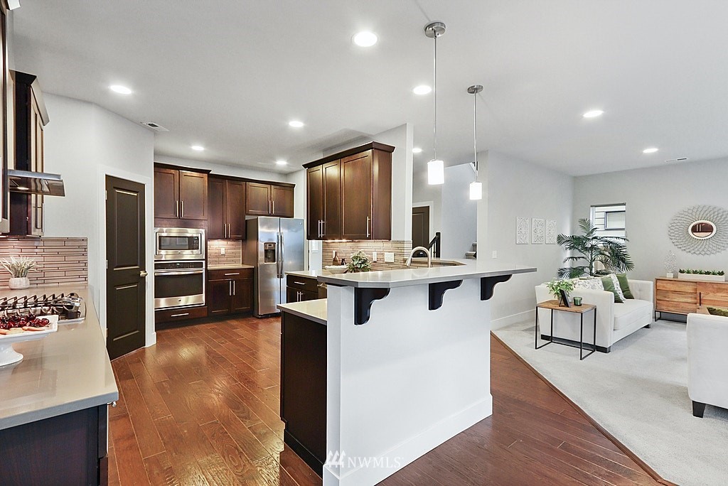 16808 1st Avenue West Bothell, WA 98012 - Photo 10 of 29 a kitchen with stainless steel appliances kitchen island granite countertop a refrigerator and a stove top oven