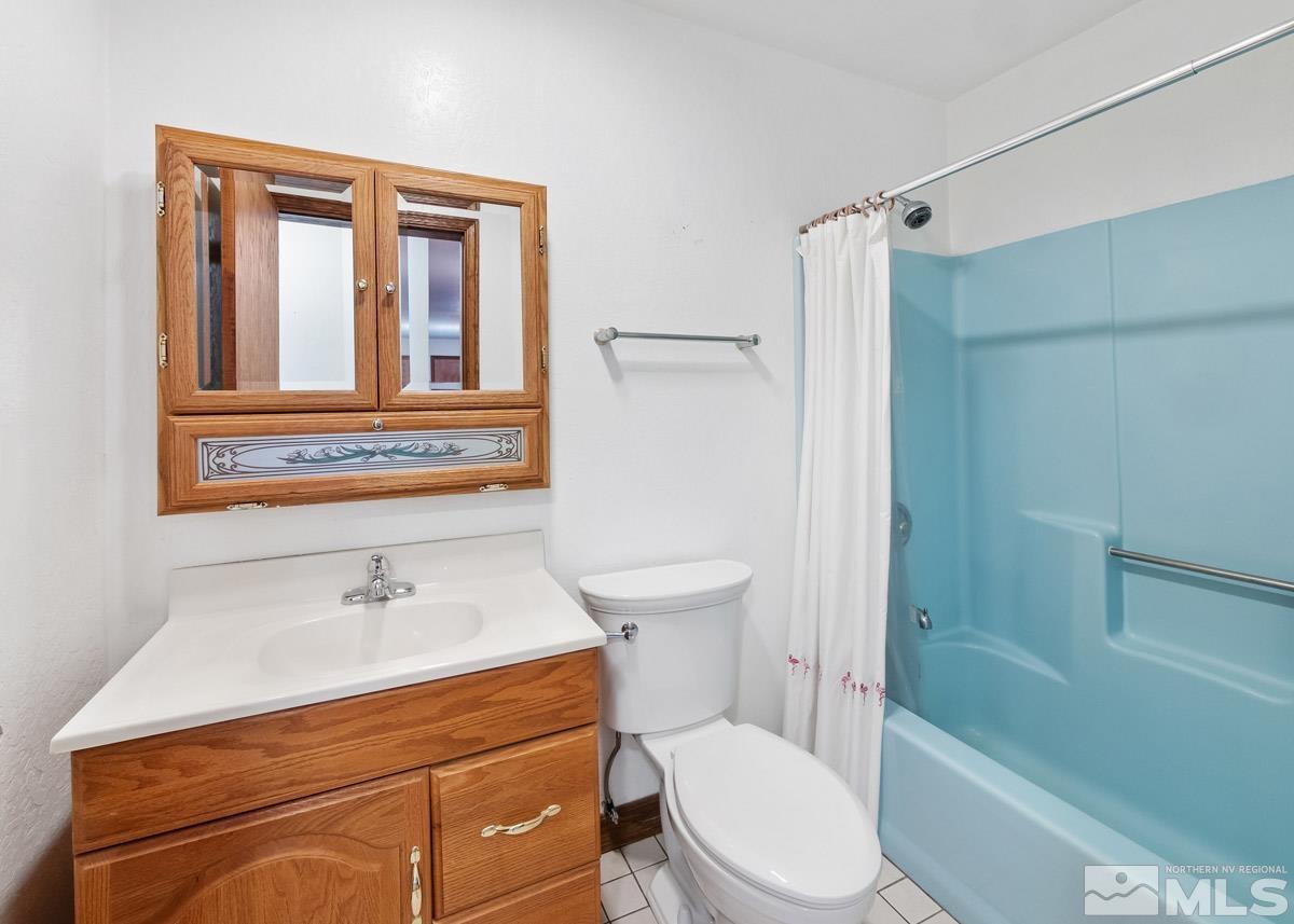 15866 Toll Road Reno, NV 89521 - Photo 19 of 29 a bathroom with a sink a mirror toilet and bathtub