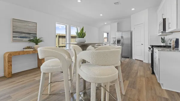 a dining room with furniture a large window and wooden floor