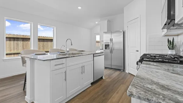 a kitchen with stainless steel appliances granite countertop a stove a sink and a refrigerator