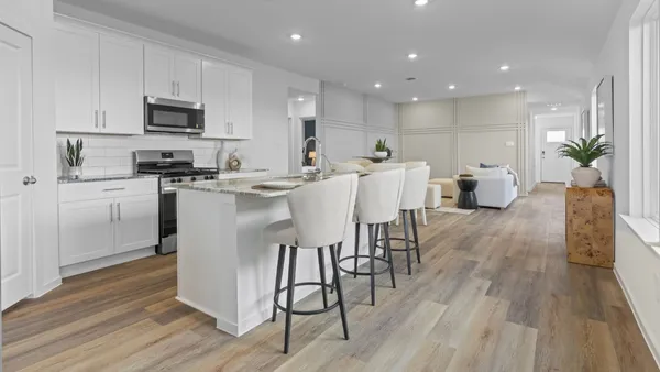 a kitchen with stainless steel appliances a dining table chairs microwave and sink