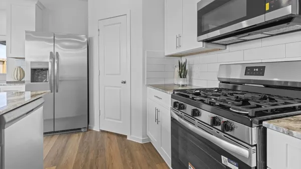 a kitchen with stainless steel appliances granite countertop a stove and a refrigerator