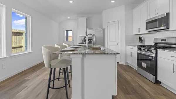 a kitchen with stainless steel appliances kitchen island granite countertop a stove a sink and a microwave