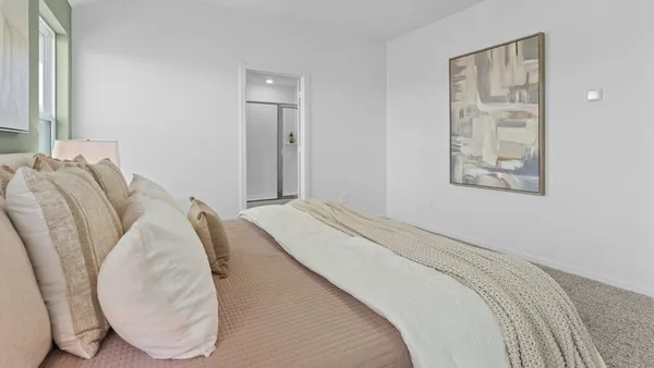 a bedroom with bed and a mirror