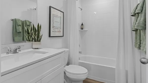 a bathroom with a granite countertop toilet sink and mirror
