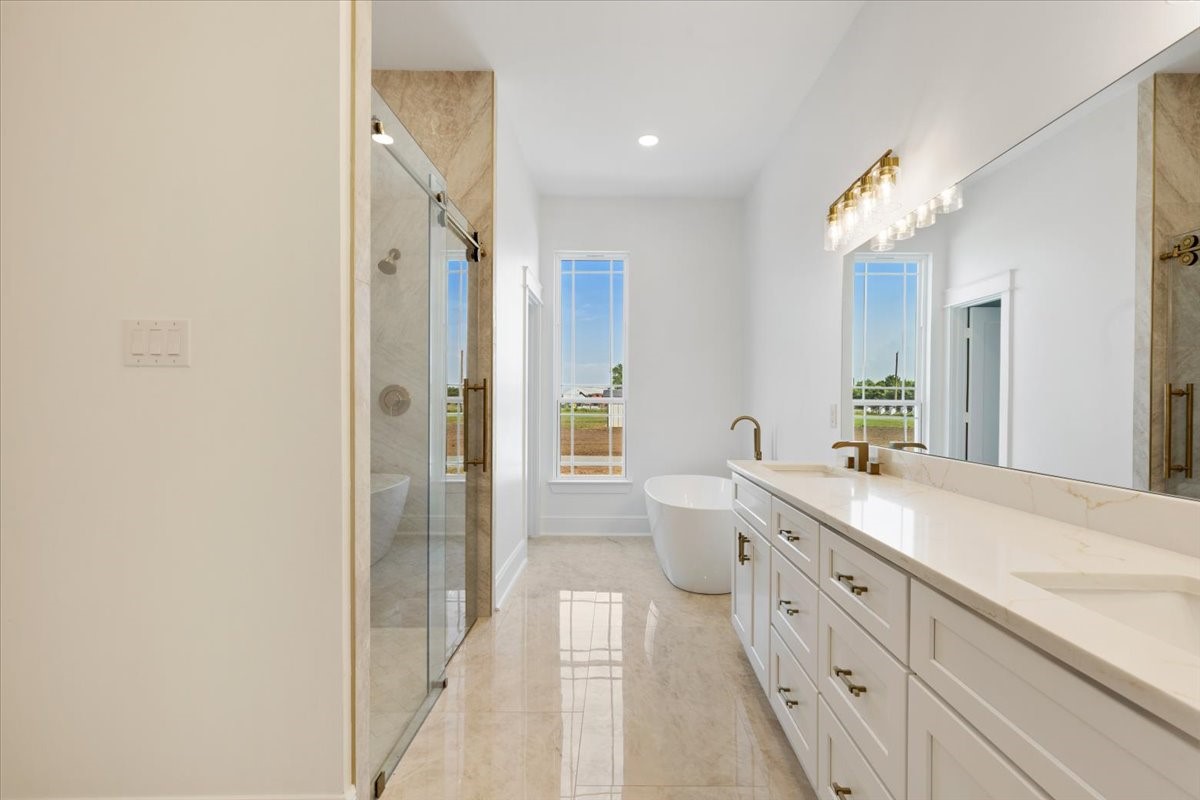 13903 Routt Point Road Needville, TX 77461 - Photo 30 of 43 a spacious bathroom with a double vanity sink mirror and a bathtub