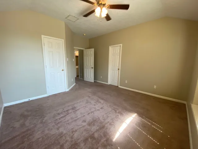 an empty room with a ceiling fan and a window