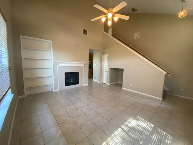 a view of an empty room with a fireplace and a window