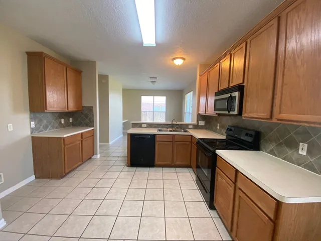 a large kitchen with stainless steel appliances granite countertop a stove a sink dishwasher a microwave oven with granite countertops and cabinets