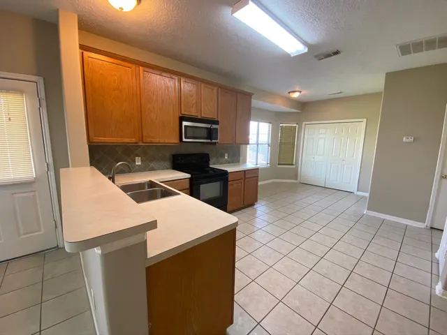 a kitchen that has a microwave a sink and a stove in it