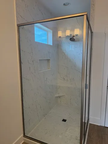 a bathroom with a glass shower door and mirror