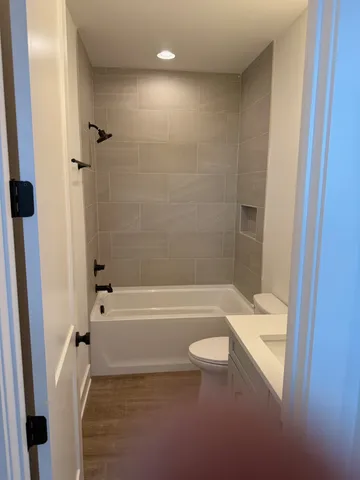 a bathroom with a granite countertop bathtub shower sink and toilet