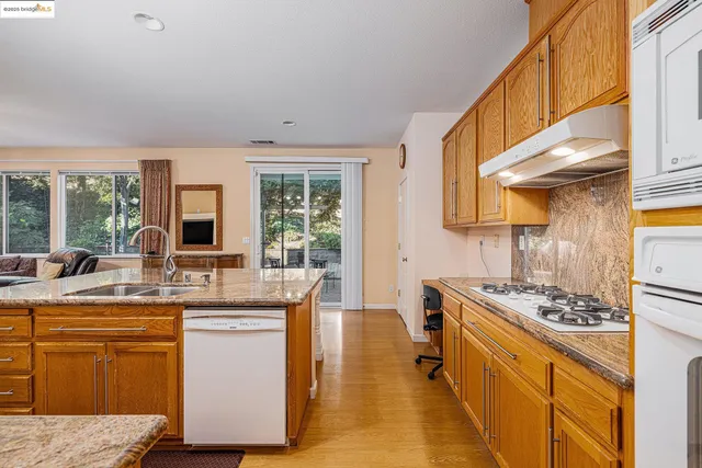 a kitchen with stainless steel appliances kitchen island granite countertop a sink stove and cabinets