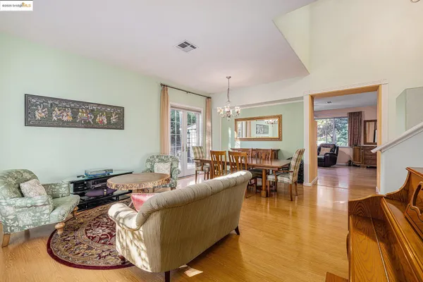 a view of a dining room with furniture a chandelier and wooden floor