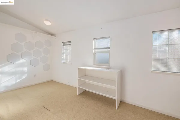 a view of empty room with refrigerator and washer