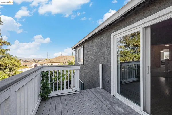 a view of backyard of house with wooden deck and entertaining space