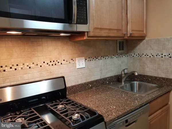 a kitchen with granite countertop a stove and a sink