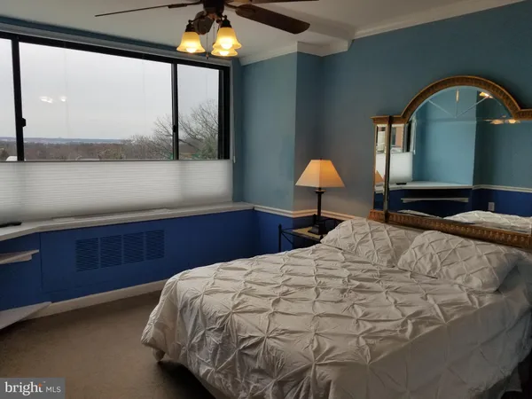 a bedroom with a bed and a large window
