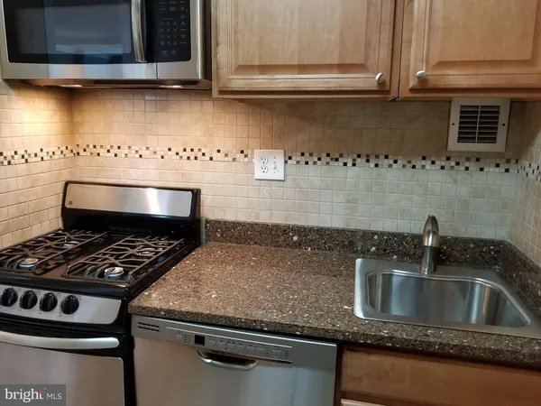 a kitchen with granite countertop a sink stove and cabinets