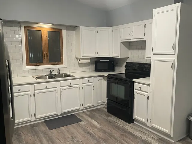 a kitchen with granite countertop white cabinets and white appliances