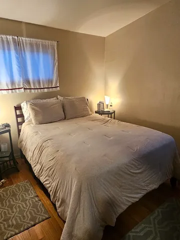 a large bed sitting in a bedroom next to a wooden cabinet