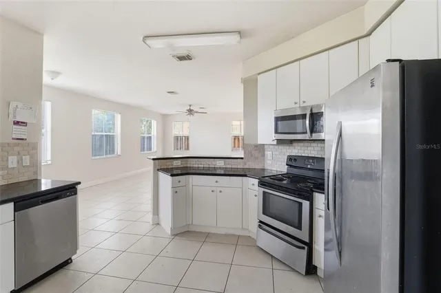 an empty room with chandelier fan