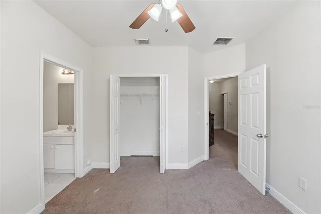 an empty room with a window and a fan