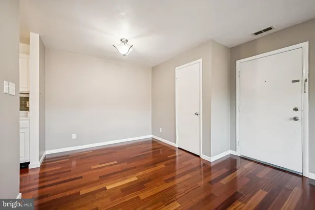 a view of an empty room with wooden floor