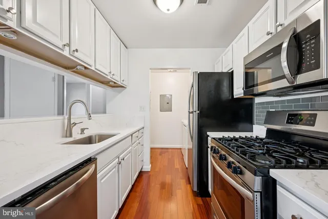a kitchen with stainless steel appliances a sink stove and refrigerator