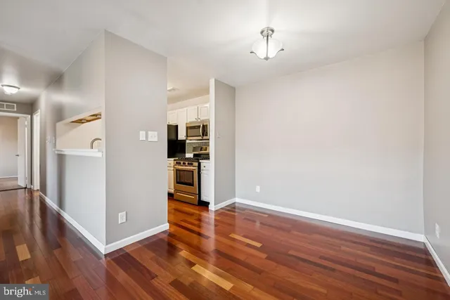a view of empty room with wooden floor