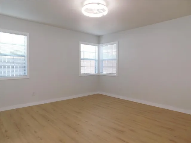 a view of an empty room with closet and a window