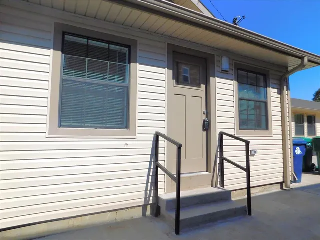 a front view of a house with a garden and yard
