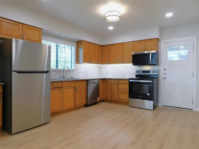 a view of a livingroom with wooden floor and windows