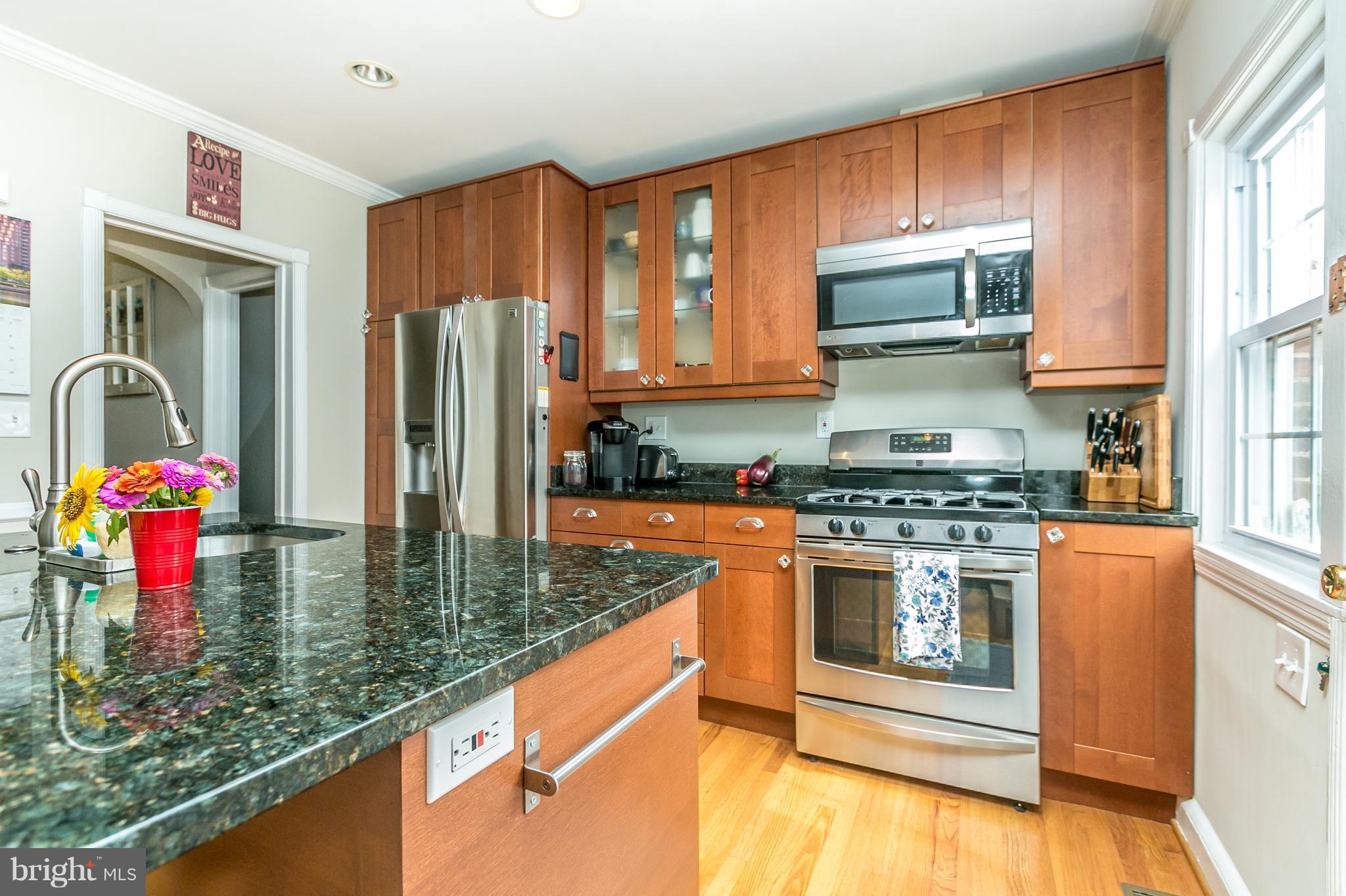 215 Dumbarton Road Baltimore, MD 21212 - Photo 11 of 30 a kitchen with stainless steel appliances granite countertop a stove a sink and a refrigerator
