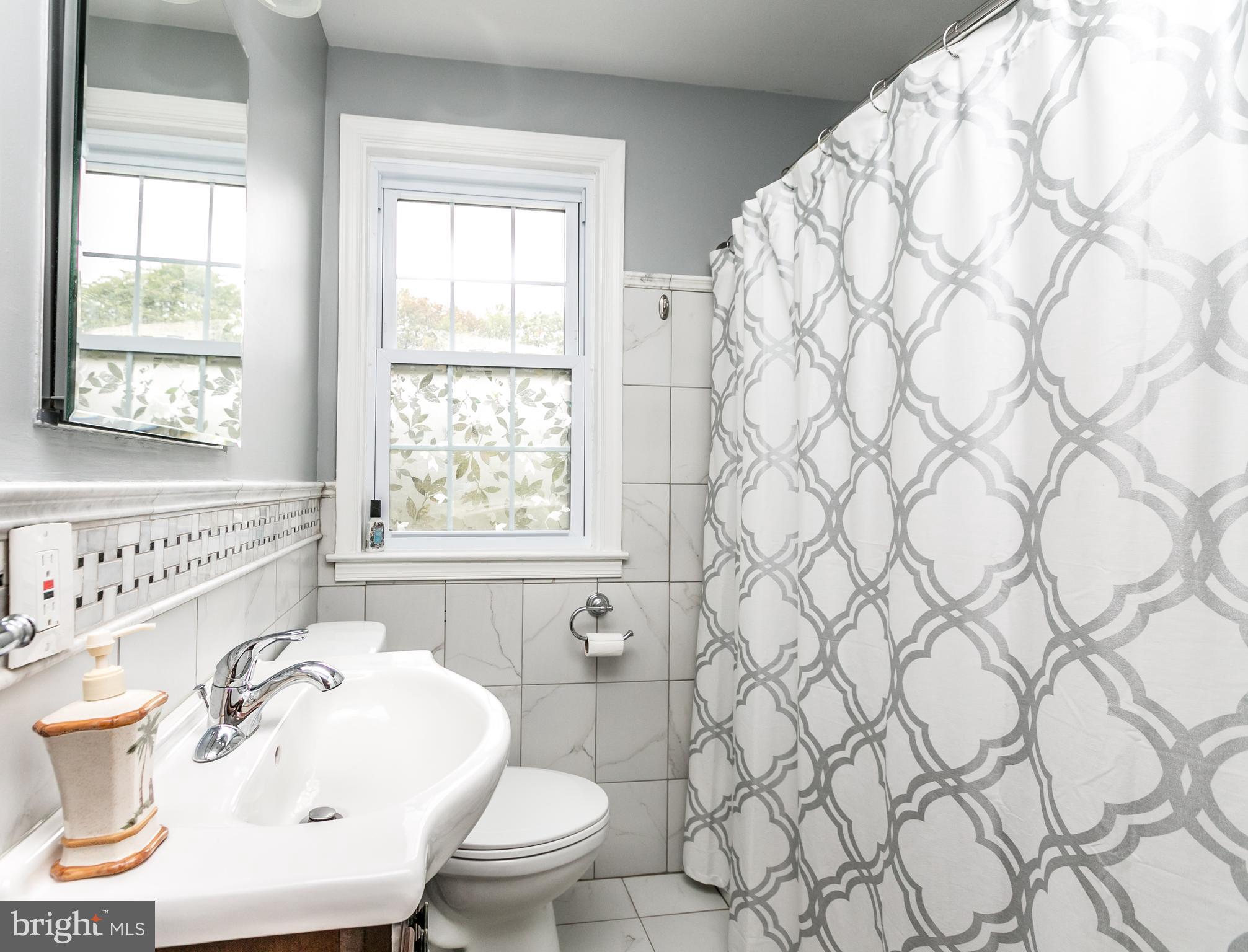 215 Dumbarton Road Baltimore, MD 21212 - Photo 21 of 30 a bathroom with a sink toilet and window