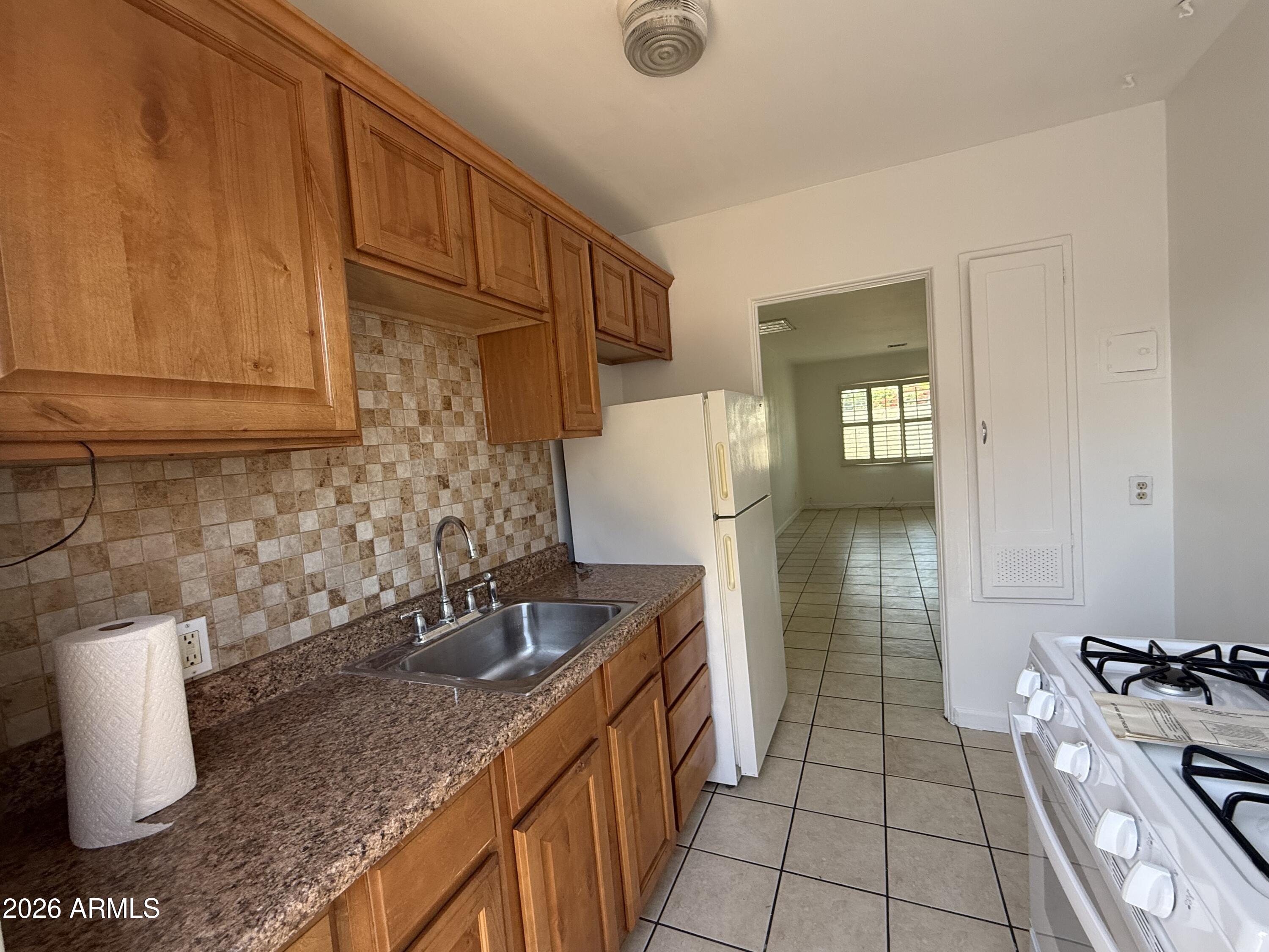 a kitchen with sink refrigerator and stove