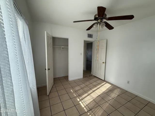 a view of a room with a shower and a ceiling fan