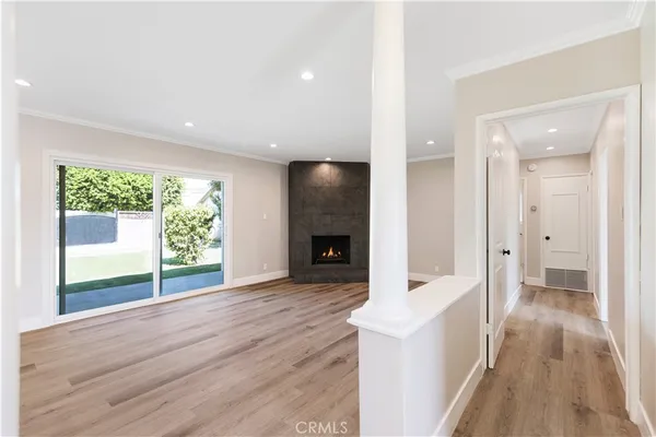 a view of a hallway with wooden floor and a fireplace