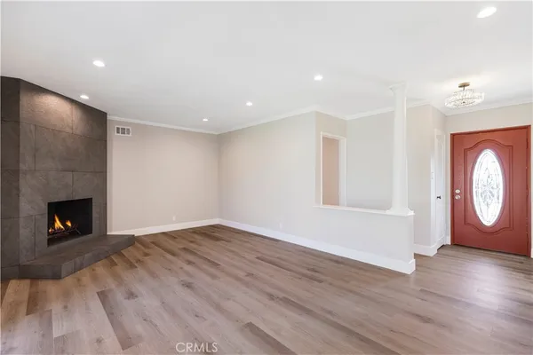 a view of a livingroom with wooden floor and a fireplace