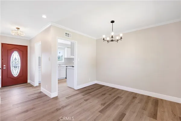 a view of a hallway with wooden floor and a large mirror