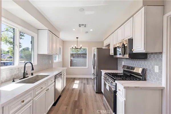 a kitchen with stainless steel appliances granite countertop a sink stove and refrigerator
