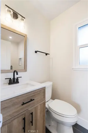 a bathroom with a granite countertop toilet sink and mirror
