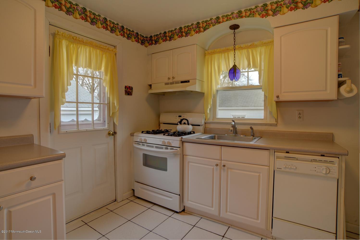 123 Robin Road Neptune Township, NJ 07753 - Photo 11 of 28 a kitchen with cabinets appliances and a window