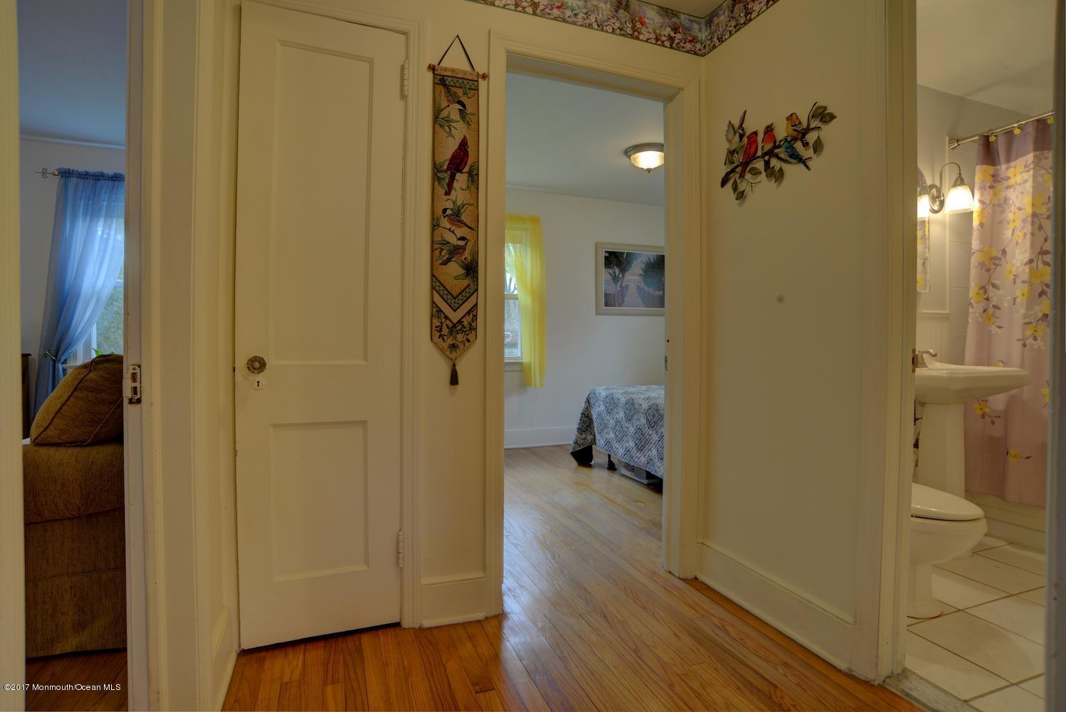 123 Robin Road Neptune Township, NJ 07753 - Photo 12 of 28 a view of a hallway with wooden floor and a bathroom